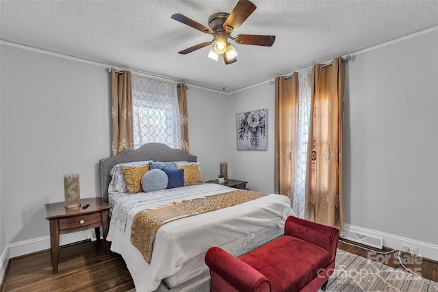 bedroom with visible vents, ornamental molding, a textured ceiling, wood finished floors, and baseboards