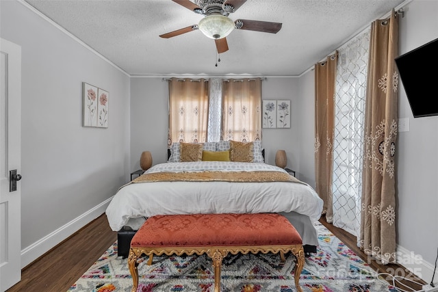 bedroom with ceiling fan, a textured ceiling, baseboards, and wood finished floors