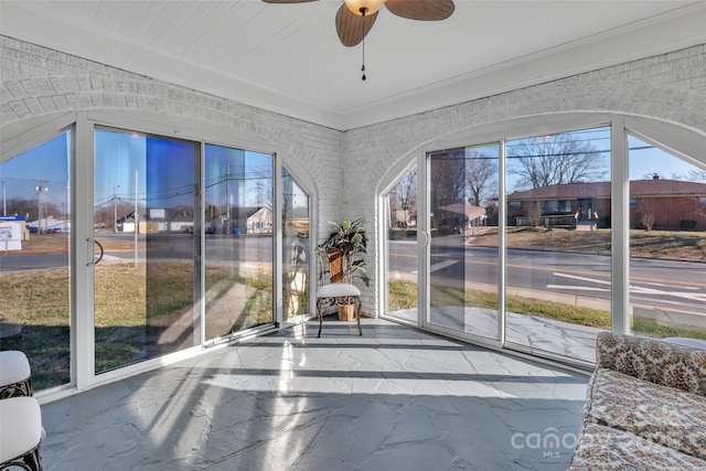 unfurnished sunroom featuring a ceiling fan