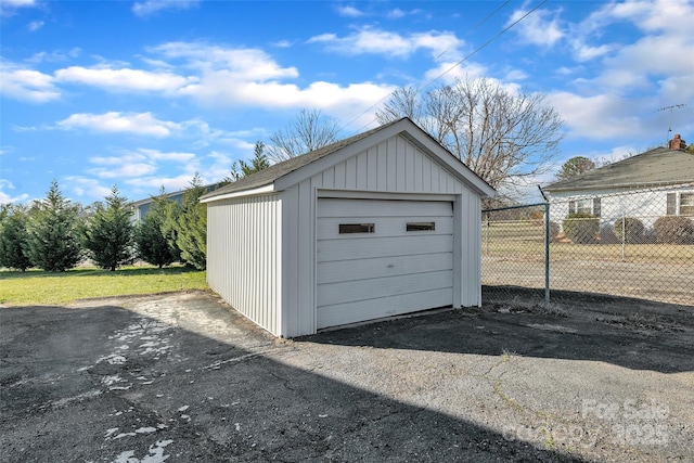 detached garage with aphalt driveway and fence