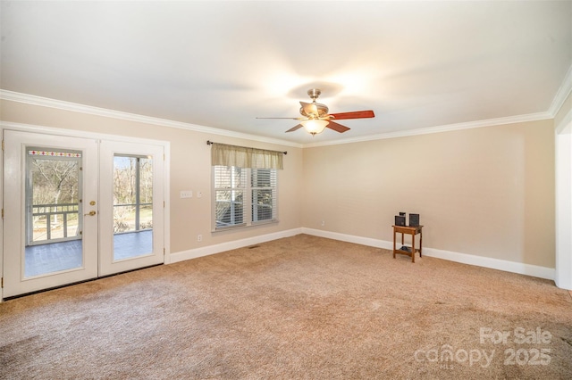 carpeted empty room with ceiling fan, baseboards, crown molding, and french doors