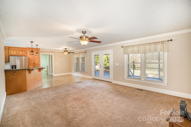 unfurnished living room featuring ornamental molding, light colored carpet, visible vents, and baseboards