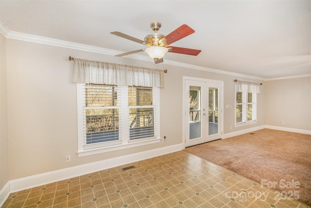 carpeted spare room featuring french doors, visible vents, crown molding, and baseboards