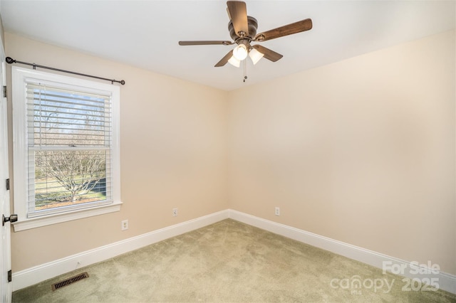 empty room with light carpet, baseboards, visible vents, and a wealth of natural light