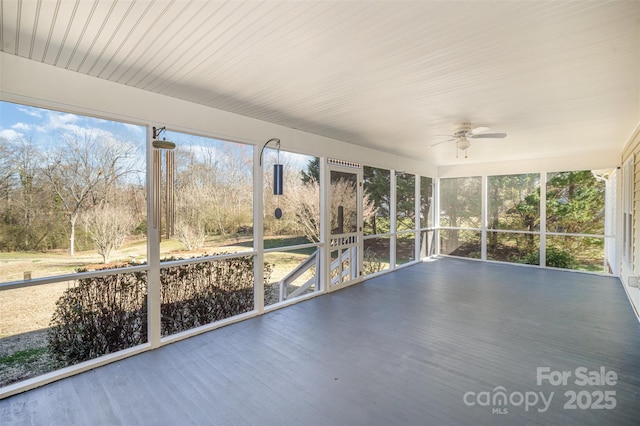 unfurnished sunroom with plenty of natural light and a ceiling fan