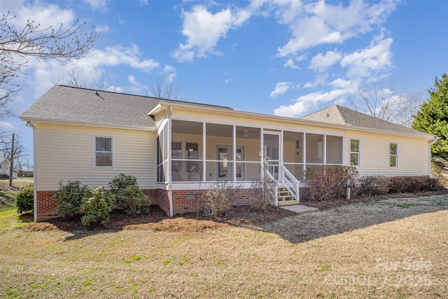 rear view of house with a shingled roof, crawl space, and a sunroom