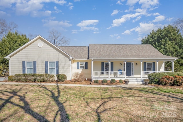 ranch-style house with covered porch, roof with shingles, and a front lawn