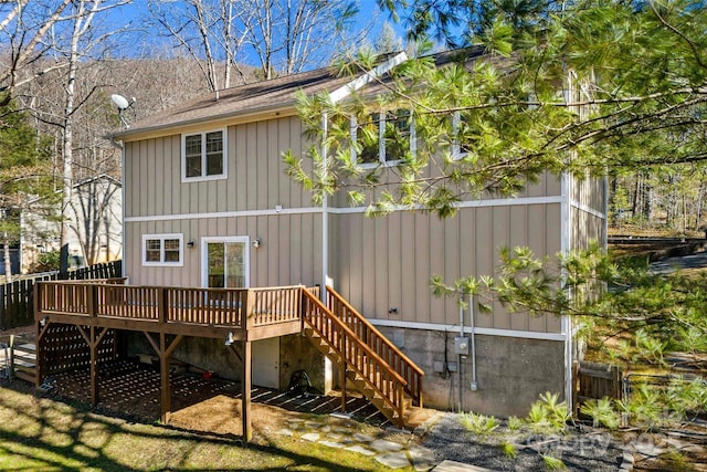 back of property with stairs, board and batten siding, and a wooden deck