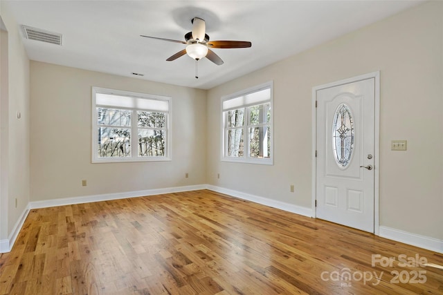 entrance foyer with light wood finished floors, baseboards, visible vents, and a ceiling fan