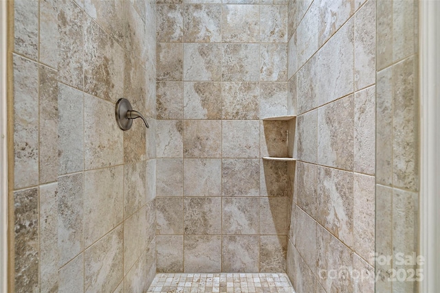 interior details with a tile shower