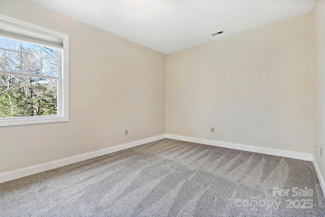 carpeted empty room featuring baseboards and visible vents