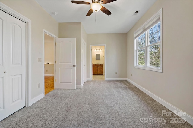 unfurnished bedroom featuring light carpet, visible vents, baseboards, and ensuite bathroom