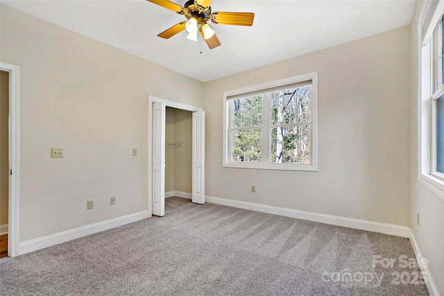 unfurnished bedroom with carpet floors, a closet, baseboards, and a ceiling fan