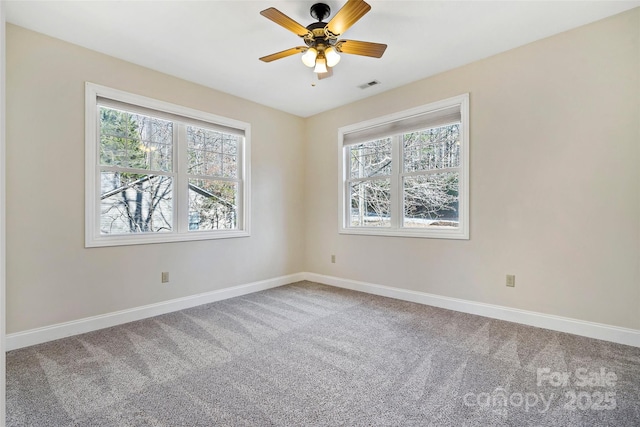 carpeted empty room with visible vents, ceiling fan, and baseboards