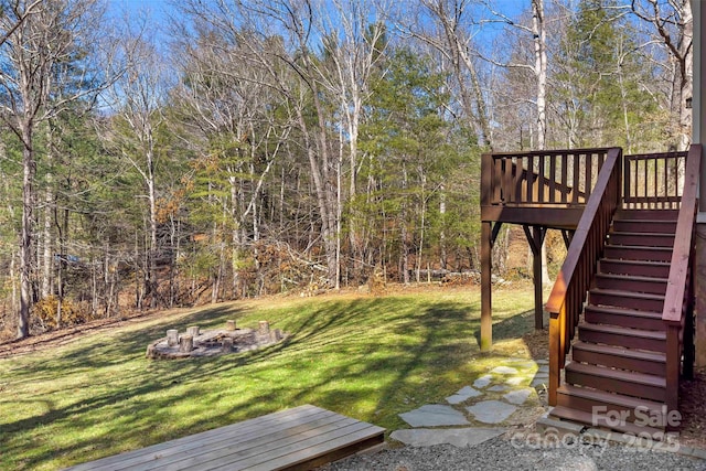 view of yard featuring an outdoor fire pit, stairs, and a wooden deck