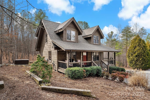 rustic home featuring covered porch and roof with shingles