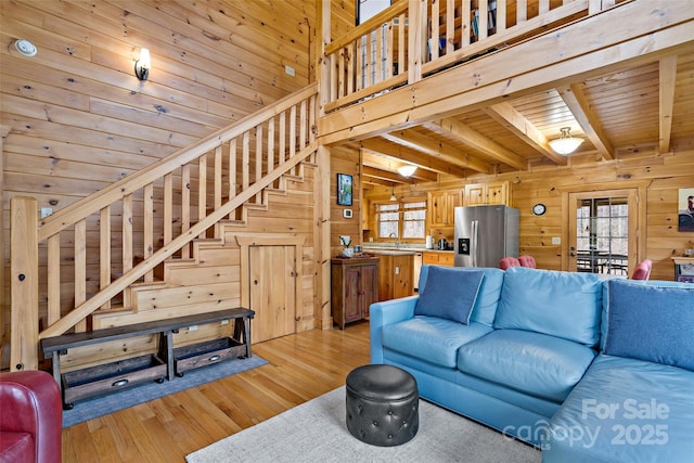 living room with a wealth of natural light, stairway, wood ceiling, and wooden walls