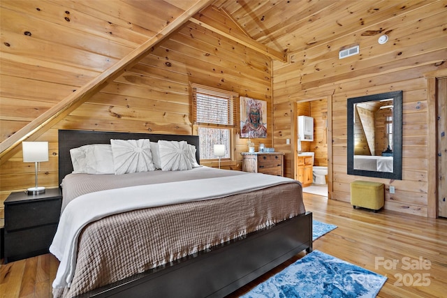 bedroom with visible vents, lofted ceiling, wooden ceiling, wood finished floors, and wood walls