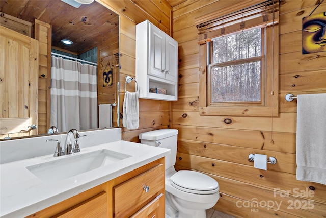 bathroom featuring toilet, a shower with curtain, wooden walls, and vanity