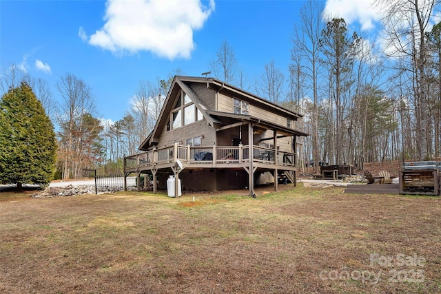 rear view of property featuring a deck and a lawn