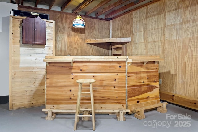 bar with a sauna, concrete flooring, a bar, wood walls, and pendant lighting