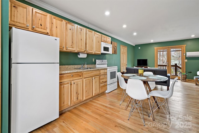 kitchen featuring light brown cabinets, white appliances, a sink, an AC wall unit, and light wood-type flooring