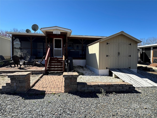 rear view of house with a storage shed and an outbuilding