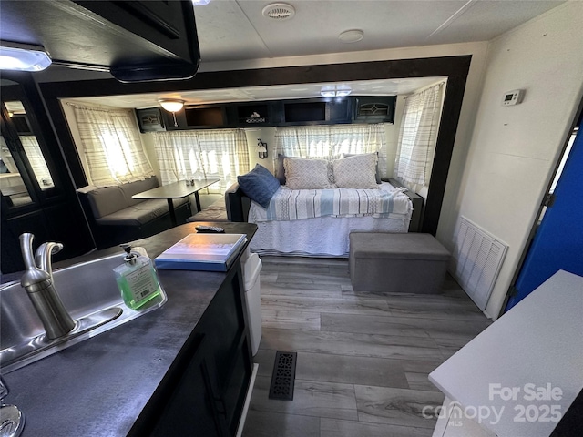 interior space featuring dark wood-style flooring, a sink, and visible vents