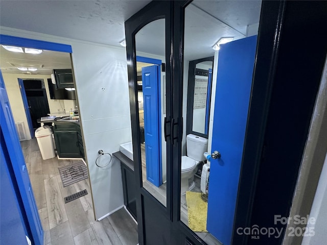 bathroom featuring visible vents, toilet, and wood finished floors