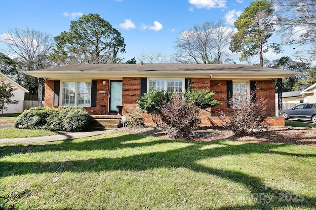 ranch-style house featuring a front yard and brick siding