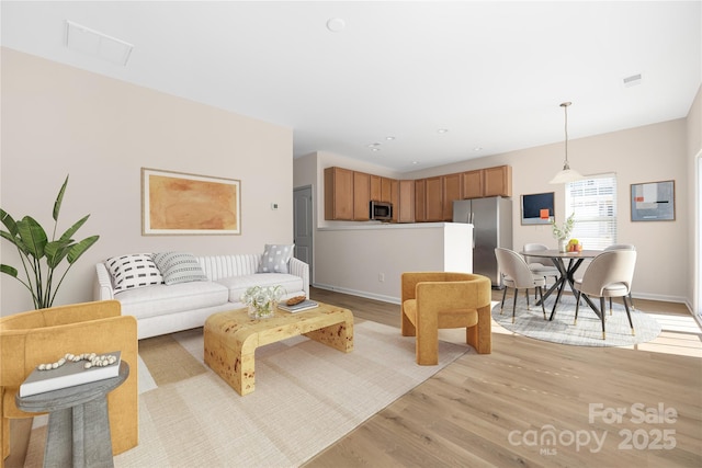 living room featuring recessed lighting, visible vents, light wood-style flooring, and baseboards