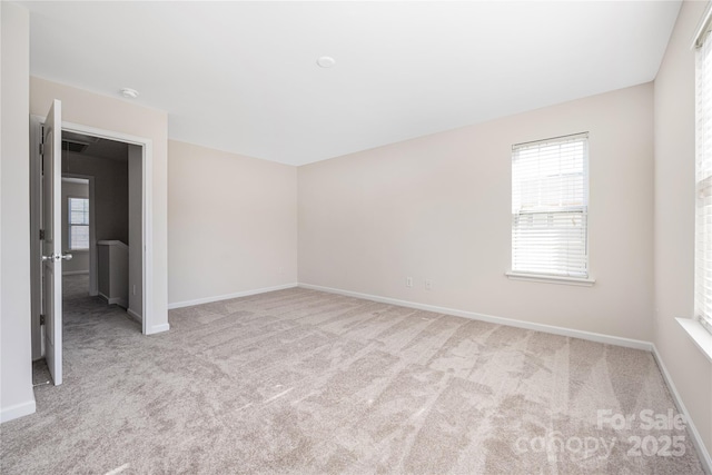 spare room featuring baseboards and carpet flooring