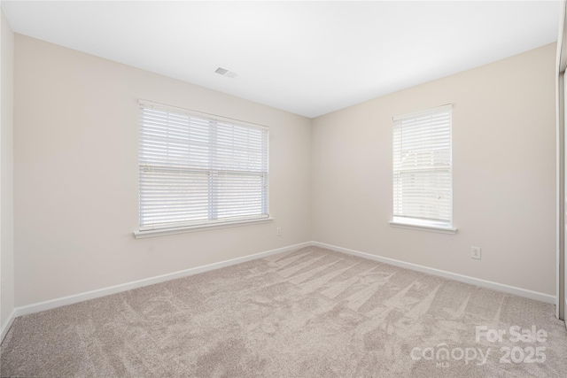 empty room with light carpet, baseboards, and visible vents