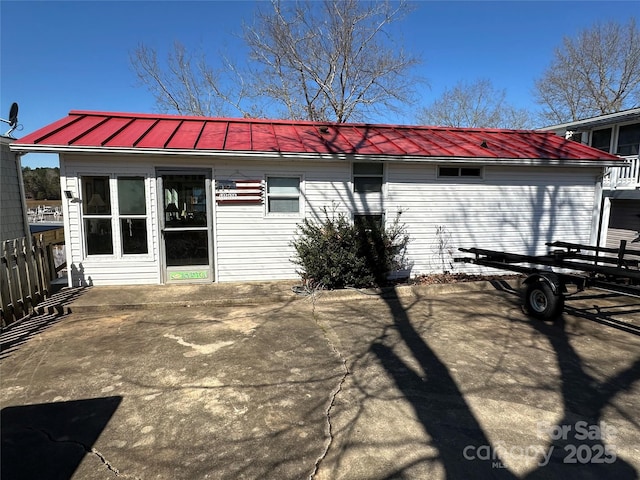 rear view of house with metal roof and a patio