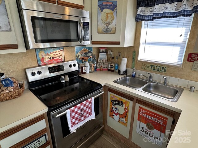 117 Badin Lake Cir, New London, NC 28127 - kitchen with stainless steel appliances, decorative backsplash, light countertops, and a sink