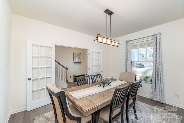 dining area with a notable chandelier, stairway, wood finished floors, and baseboards