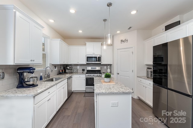 kitchen featuring white cabinets, dark wood-type flooring, stainless steel appliances, and a sink