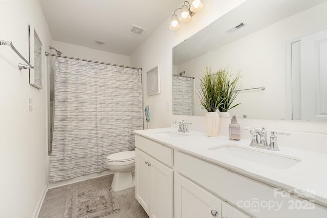 bathroom featuring toilet, a sink, and visible vents