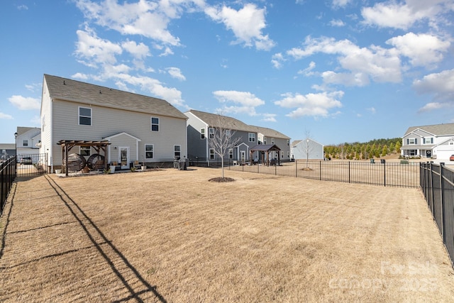 back of property featuring a residential view, a fenced backyard, a yard, and a pergola