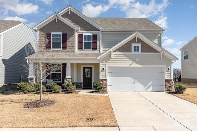 craftsman-style house with a garage, concrete driveway, a porch, and stone siding