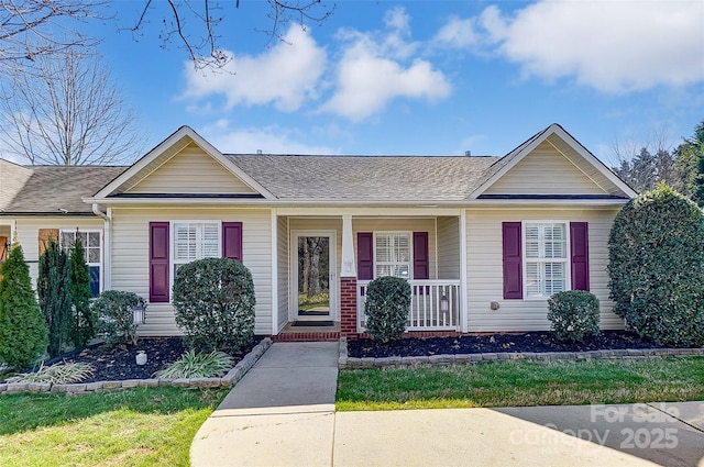 single story home with covered porch and roof with shingles