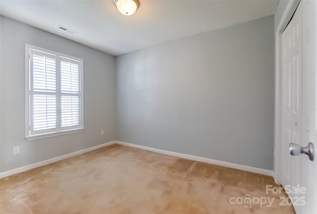 spare room featuring light carpet, baseboards, and visible vents