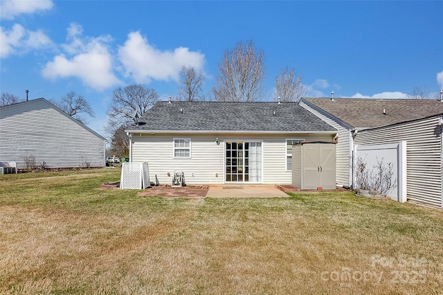 back of house featuring a patio, a lawn, and roof with shingles