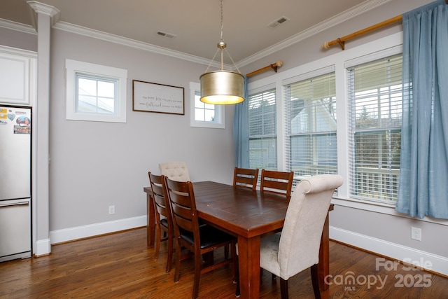 dining area with ornamental molding, dark wood-style flooring, visible vents, and baseboards