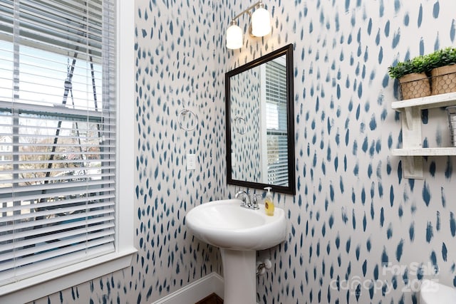 bathroom featuring baseboards and wallpapered walls