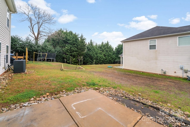 view of yard with a patio area, a trampoline, and central AC