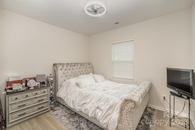 bedroom featuring visible vents, light wood-style flooring, and baseboards