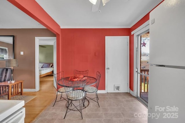 dining area with light wood-style floors, ceiling fan, and baseboards