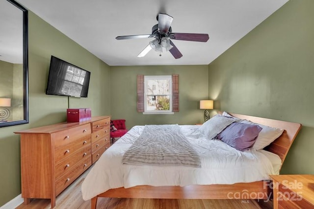 bedroom featuring baseboards, light wood-style flooring, and a ceiling fan