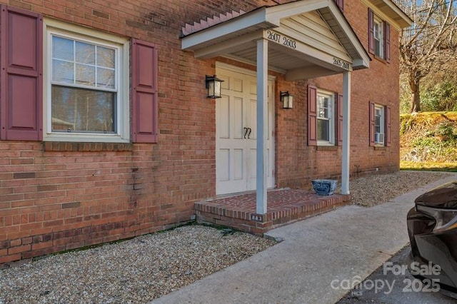 view of exterior entry featuring brick siding